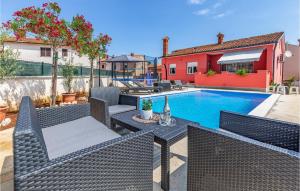 un cortile con piscina, sedie e una casa di 3 Bedroom Awesome Home In Marcana a Marčana