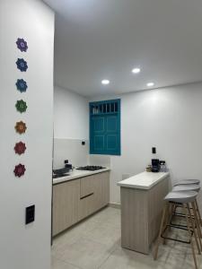 a kitchen with green and white walls and a counter at Encantador y acogedor Apartamento in Filandia