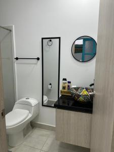 a bathroom with a toilet and a mirror at Encantador y acogedor Apartamento in Filandia +20 photos