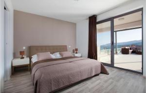 Un dormitorio con una cama grande y una ventana grande. en Nice Home In Rabac With Wifi, en Rabac