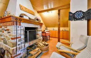 a living room with a stone fireplace and a table at Lovely Home In Dreznica With Sauna in Jagetići