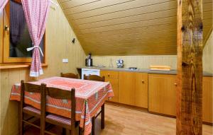 a dining room with a table and a kitchen at Lovely Home In Dreznica With Sauna in Jagetići