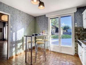 a kitchen with a table and chairs and a window at Gîte Le Karrdi in Landavran