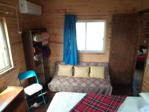a living room with a couch and a window at Cactus in Punta Del Diablo