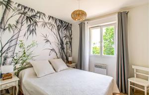 ein Schlafzimmer mit einem Bett mit tropischer Tapete in der Unterkunft Stunning Home In Beauville With Kitchen in Beauville