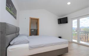 a white bedroom with a bed and a balcony at Lovely Home In Donji Prolozac With Wifi in Donji Proložac