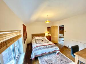 a bedroom with a bed and a window at Bumblebee Cottage in Knowle