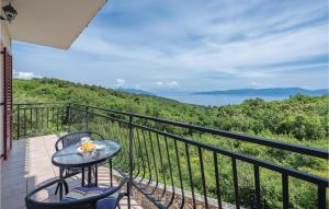 stół i krzesła na balkonie z widokiem na ocean w obiekcie 2 Bedroom Beautiful Apartment In Labin w mieście Drenje