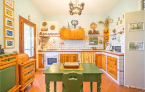 una cocina con armarios de madera y una mesa verde en Beautiful Home In Partinico Pa, en Balestrate