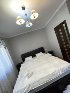 a bedroom with a bed with white sheets and lights at Victoriei light studio in Bucharest