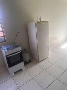 a kitchen with a stove and a refrigerator at Apartamento Alecrim in São Roque de Minas
