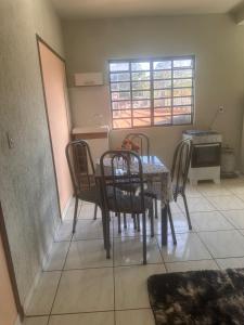 a dining room with a table and four chairs at Apartamento Alecrim in São Roque de Minas
