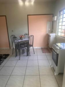 a dining room with a table and chairs and a kitchen at Apartamento Alecrim in São Roque de Minas