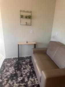 a living room with a couch and a table at Apartamento Alecrim in São Roque de Minas