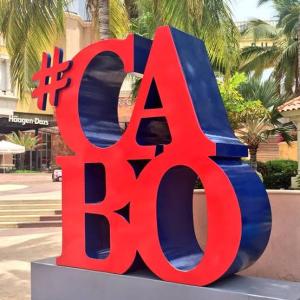 a large red and blue sign on a street at Harbour Junior suites in Cabo San Lucas