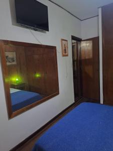 a bedroom with a mirror and a tv on the wall at Morada urbana pleno centro in Posadas