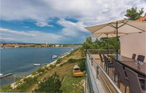 balkon z parasolem i widokiem na rzekę w obiekcie 6 Bedroom Cozy Apartment In Nin w Nin