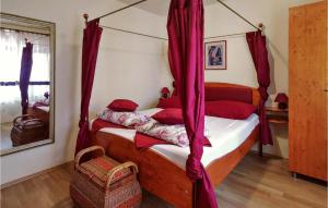 una camera con letto a baldacchino e cuscini rossi di Two-Bedroom Holiday Home In Pula a Pola (Pula)