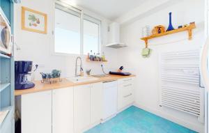 eine weiße Küche mit Spüle und Fenster in der Unterkunft 2 Bedroom Awesome Apartment In Royan in Royan