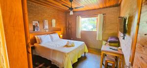 a small bedroom with a bed and a window at Cores e Flores da Serra Pousada by Concavus in Santo Antônio do Pinhal