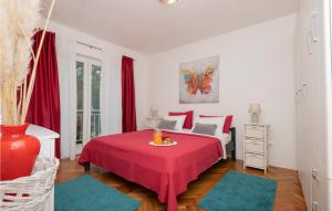 a bedroom with a red bed with a red table at Three-Bedroom Holiday Home In Vinjani Gornji in Aračići