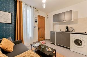 a living room with a couch and a kitchen at Charmant duplex à deux pas de Paris et du RER B in Gentilly
