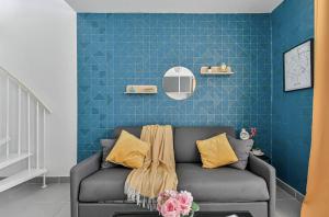 a living room with a couch and a blue wall at Charmant duplex à deux pas de Paris et du RER B in Gentilly