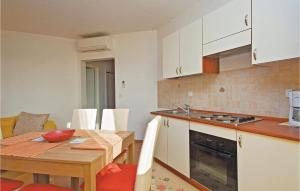 - une cuisine et une salle à manger avec une table et une cuisinière dans l'établissement Apartment Vodnjan Peroj Ii, à Vodnjan