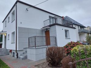 a white house with a balcony on the side of it at Apartament Muszelka in Puck