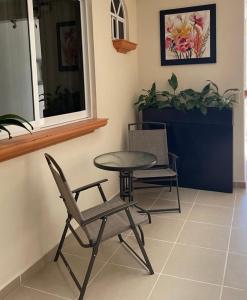 a table and two chairs and a table and a window at Galex Hotel Posada in Huajuapan de León
