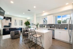 Una cocina y una sala de estar con mostrador y sillas. en La Veranda View Hideaway, en Los Ángeles