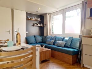 a living room with a blue couch and a table at Cap Valras - Les sables du midi in Valras-Plage