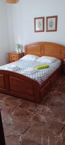 a wooden bed with a green object on top of it at SwordFish Cliff Apartment in Peniche +4 photos