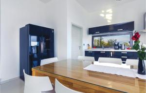 jadalnia ze stołem i białymi krzesłami w obiekcie 4 Bedroom Beautiful Home In Labin w mieście Vicani