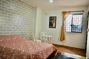 una camera da letto con un letto, una finestra e un tavolo di Apartaestudios la terraza 2 a Sincelejo
