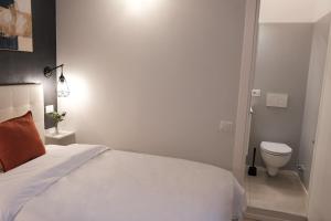 a bedroom with a white bed and a toilet at Numi B&B in Rome
