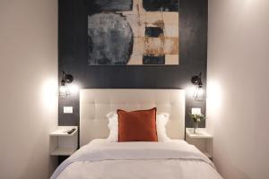 a bedroom with a white bed with a orange pillow at Numi B&B in Rome