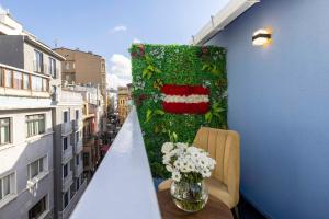 a balcony with a ivy covered wall and a vase of flowers at Santa Rio Gold Taxim Hotel in Istanbul