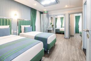 a hotel room with two beds with green and white at Santa Rio Gold Taxim Hotel in Istanbul
