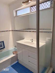 Un baño con lavabo, espejo y bañera. en Room near airport CBD, en Perth