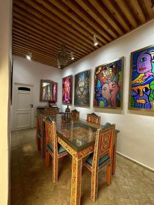a dining room with a table and chairs and paintings at Dar Mounia in Rabat +49 photos