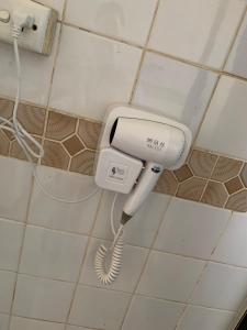 um telefone no canto de uma casa de banho em Nadi Airport rooms em Nadi