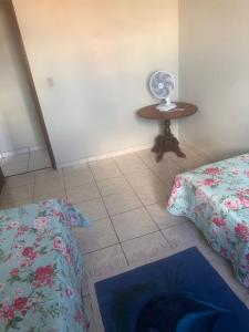 a bedroom with a bed and a table with a fan at Apartamento Alecrim in São Roque de Minas