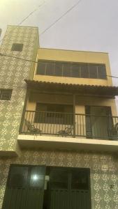 a tall building with a balcony and a window at Apartamento Alecrim in São Roque de Minas