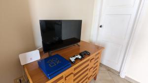 a tv on a wooden dresser with two video game controllers at Golf Heights Resort - Sea and Mountain View - Free WIFI - Sharm El Sheikh in Sharm El Sheikh