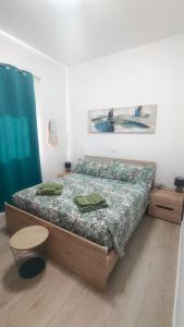 a bedroom with a bed with green towels on it at Casa Luna y Sol in Puerto del Rosario