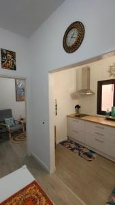 a kitchen with a clock on the wall at Casa Luna y Sol in Puerto del Rosario