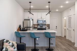 a kitchen with white cabinets and blue stools at Tourist Home of Richmond - Church Hill North APT04 in Richmond +7 photos