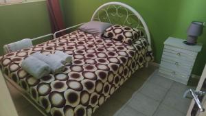 a bed in a green room with a large bed with at Djon’s Place in Mindelo