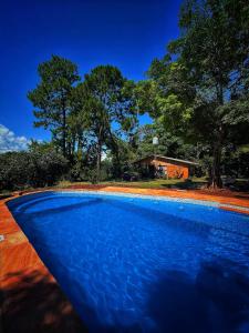 una piscina azul frente a una casa en La casita de Mari, en Ruiz de Montoya